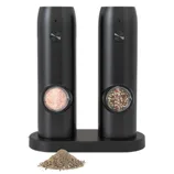 Black electric salt and pepper grinders on a charging base, featuring a window showing pink salt and mixed peppercorns, with freshly ground pepper scattered in front.