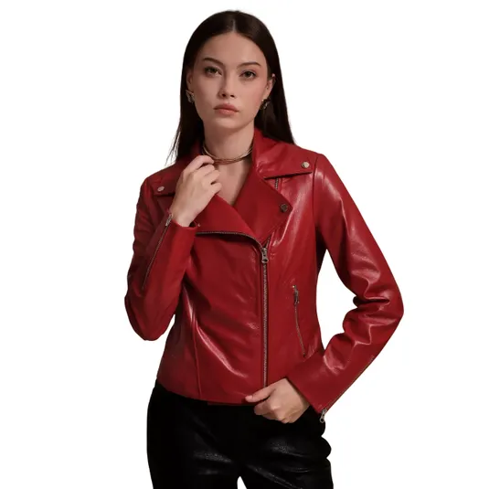 A woman is wearing a red leather motorcycle jacket with asymmetrical zippers and silver hardware, paired with black pants.