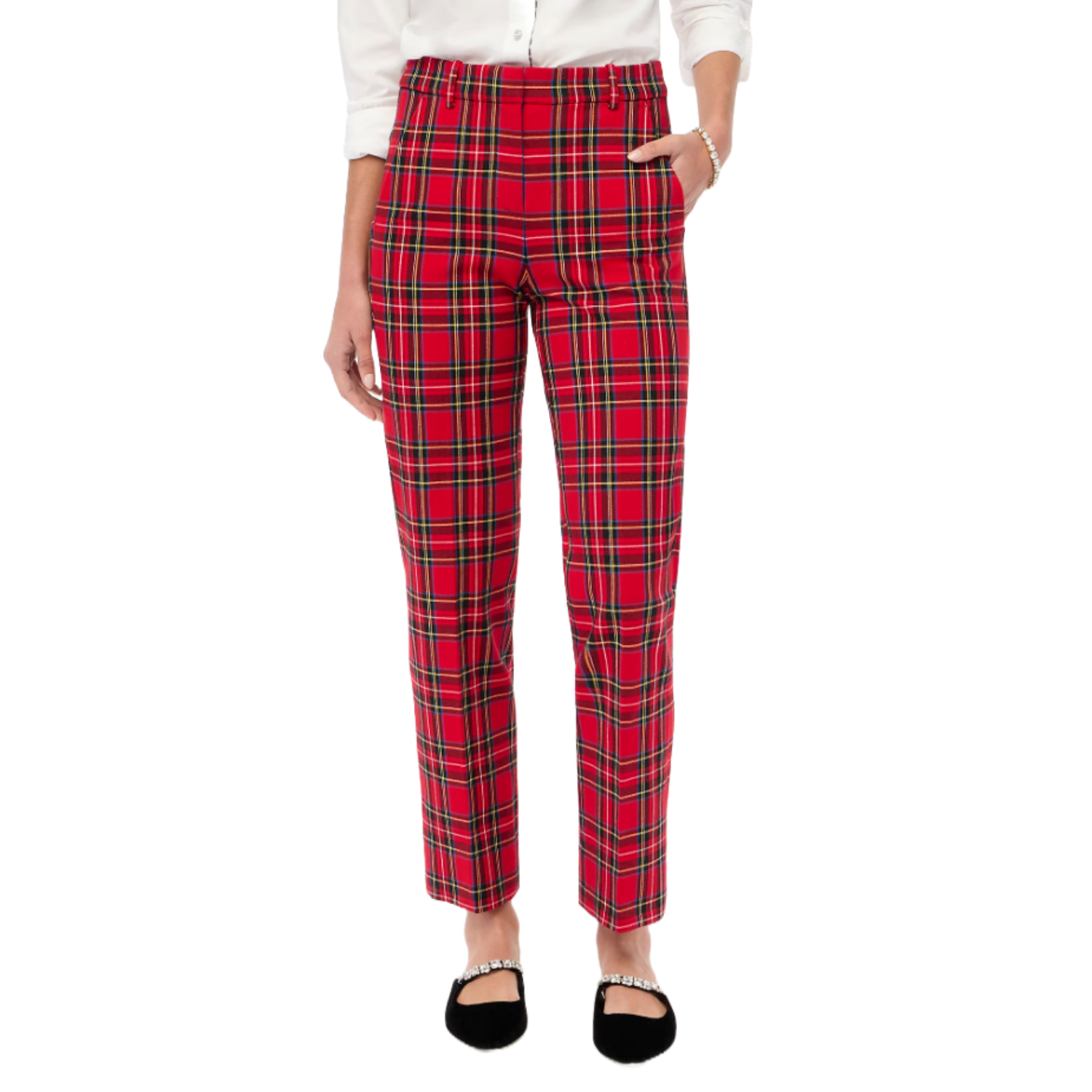 A person wears red plaid pants paired with a white shirt and black flat shoes featuring decorative straps.
