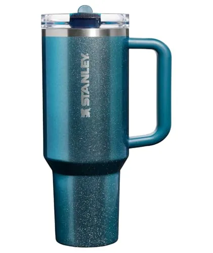Stanley insulated travel mug in a teal color with a handle and a clear lid, designed to keep beverages hot or cold.