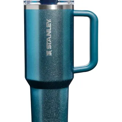 Stanley insulated travel mug in a teal color with a handle and a clear lid, designed to keep beverages hot or cold.