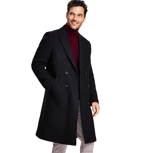 The Tommy Hilfiger Modern-Fit Overcoat is a sleek, double-breasted black coat with a tailored fit. It features a classic notched lapel and is worn over a burgundy turtleneck and plaid pants, blending classic and contemporary styles.