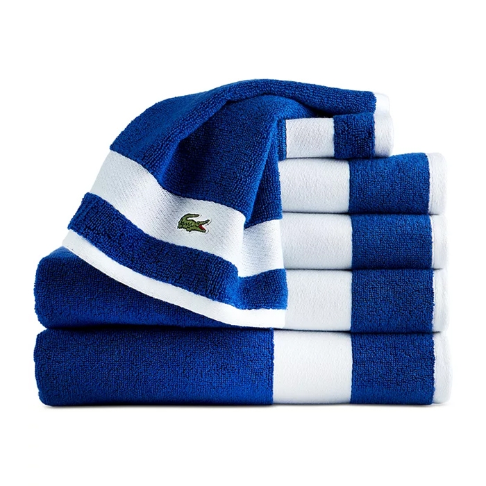 A stack of blue and white striped towels with a small green crocodile logo.