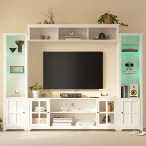 A white entertainment center with shelves and cabinets, holding a flat-screen TV, books, decor items, speakers, and a record player. Soft lighting highlights the shelves.