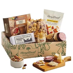 A Harry & David Snack Box containing mixed nuts, cheddar cheese, sausage, mustard, three-seed crackers, and caramel popcorn. All items are packed in a decorative box.