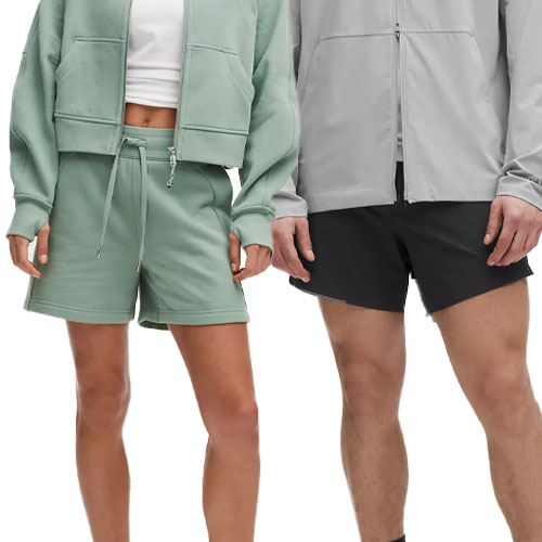 Two people are wearing casual activewear; one in a green set with a zip-up jacket and drawstring shorts, and the other in a gray jacket with black shorts.