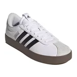 White Adidas sneaker with black stripes, a brown sole, and a suede toe cap.