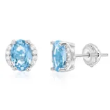 Pair of stud earrings featuring oval blue gemstones set in a silver prong setting, accented with small clear stones on the sides, and secured with screw-back posts.