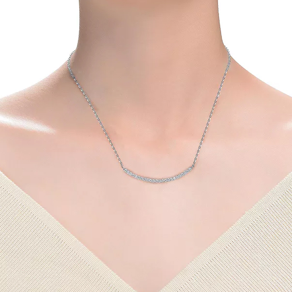 A minimalist sterling silver necklace featuring a delicate chain with a small, curved bar encrusted with cubic zirconia stones, adding subtle sparkle.