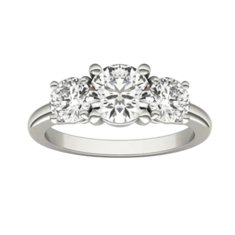 A three-stone diamond ring featuring a larger central round diamond flanked by two smaller round diamonds set in a silver band.