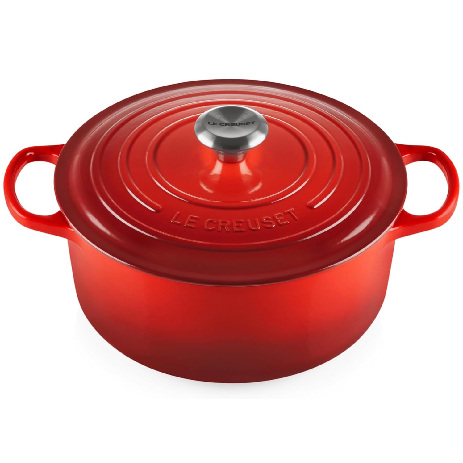Red Le Creuset Dutch oven with a round shape, featuring a stainless steel knob on the lid and two loop handles. Made of enameled cast iron, designed for even heat distribution and retention.
