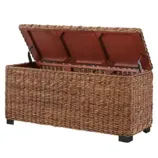 Woven storage box with a hinged lid, featuring a natural rattan appearance on four black legs, providing a stylish storage solution.