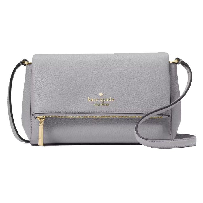 A light gray Kate Spade New York crossbody bag with a pebbled leather texture, featuring a gold logo, a front zipper pocket, and an adjustable strap.