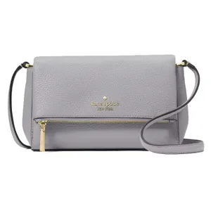 A light gray Kate Spade New York crossbody bag with a pebbled leather texture, featuring a gold logo, a front zipper pocket, and an adjustable strap.