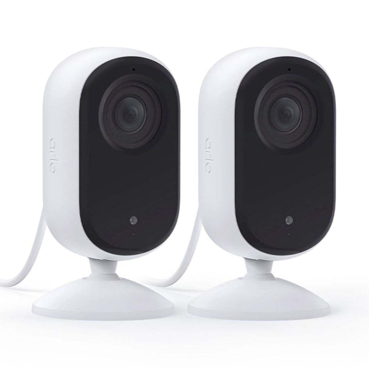 Two Arlo security cameras with a sleek black and white design, featuring a single lens and mounted on a white stand with a connected power cable.