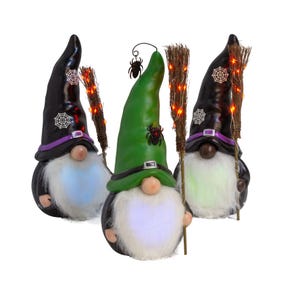 Three decorative Halloween gnomes with beards, pointed hats, and light-up brooms, in black, green, and purple attire.