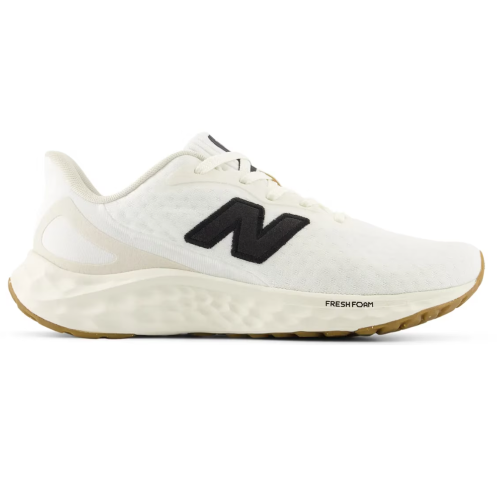 White New Balance running shoe featuring a black \“N\“ logo and \“Fresh Foam\“ cushioning, with a gum sole.