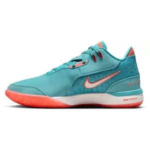 Nike LeBron NXXT Basketball Shoes feature a teal upper with coral accents, including a prominent Swoosh logo. The design includes a white midsole with a coral outsole and Air Zoom cushioning for performance.