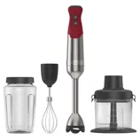 A stick blender set with a red handle, accompanied by accessories: a measuring blender cup, a whisk attachment, and a food processor bowl with lid.