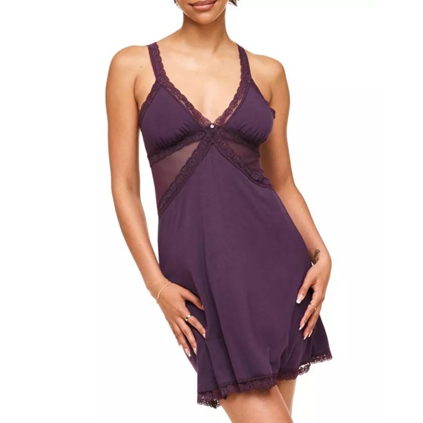 Purple slip dress featuring lace trim, mesh panels, and adjustable straps, with a delicate, feminine design.