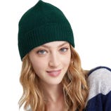 A person wearing a green knit beanie and a blue and gray striped sweater.