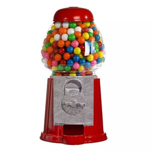 A red classic gumball machine with a glass globe filled with colorful gumballs, featuring a coin-operated mechanism and a silver base with embossed designs.
