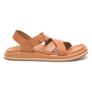 A tan sandal with a cross-strap design, adjustable ankle strap, and a flat sole featuring subtle stitching.
