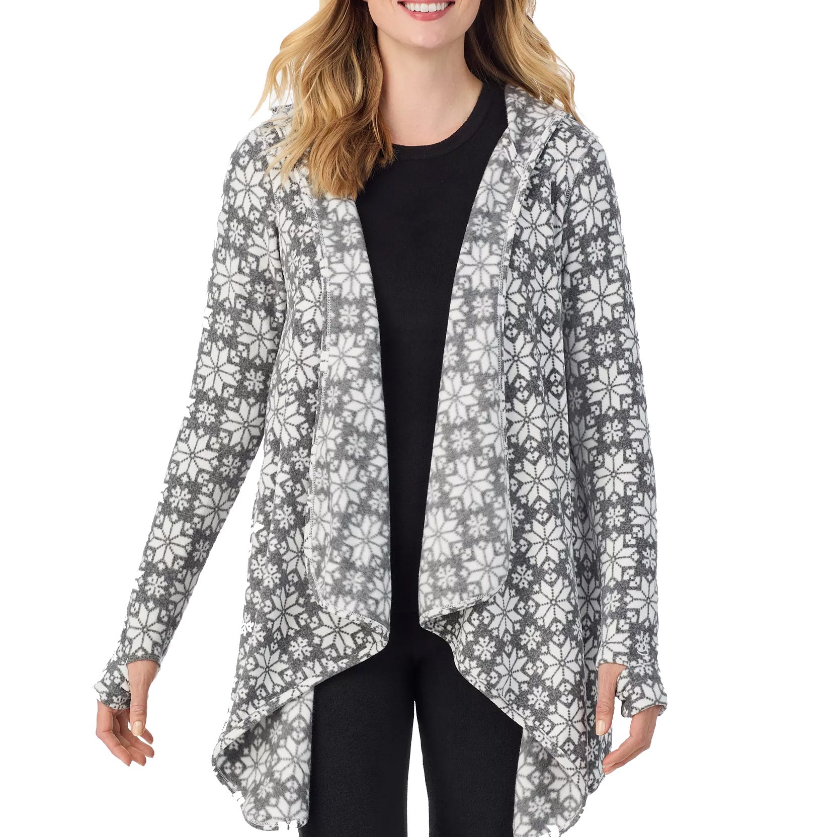 A woman wearing a gray and white patterned, long-sleeve cardigan with an asymmetrical hem, over a black top and black pants.