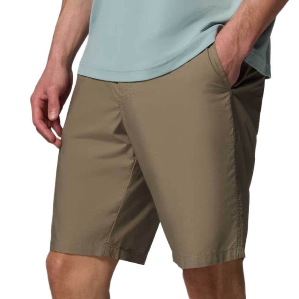 Beige knee-length shorts with side pockets worn by a person with one hand in the pocket.