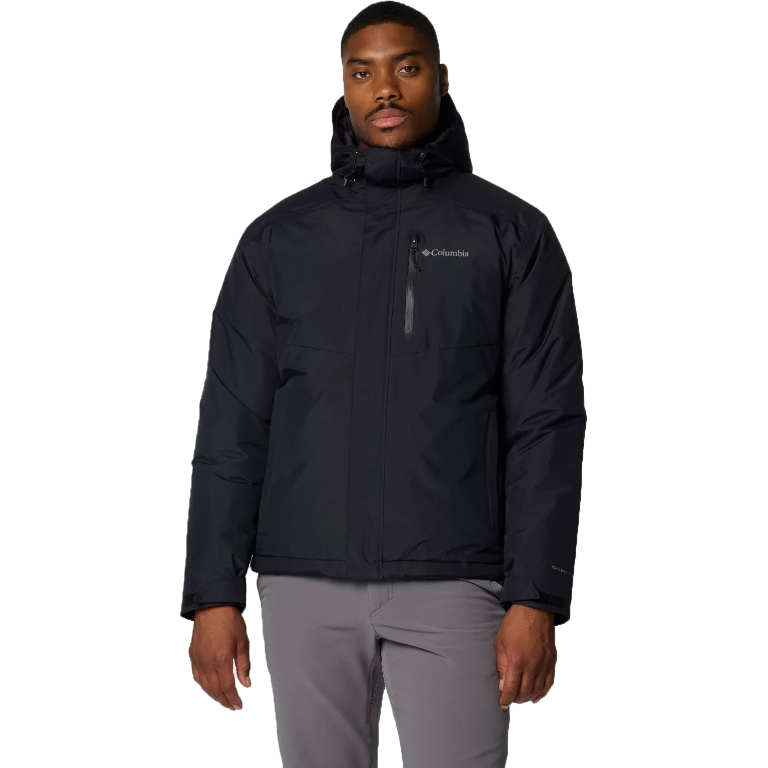 A man wearing a black Columbia hooded jacket and light gray pants.