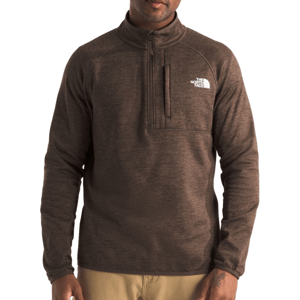 A brown quarter-zip fleece pullover with a chest pocket, featuring The North Face logo in white on the chest, paired with beige pants.