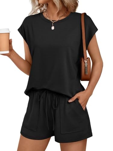 A woman wearing a black two-piece outfit consisting of a short-sleeve top and drawstring shorts, accessorized with a brown shoulder bag, a necklace, and holding a coffee cup.
