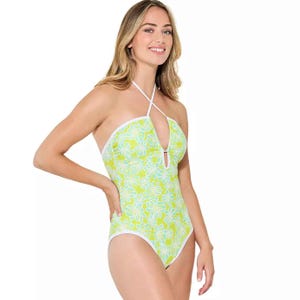 Juniors' halter one-piece swimsuit features a yellow and light blue floral pattern with white trim. It has a halter neck style and a keyhole detail at the chest.