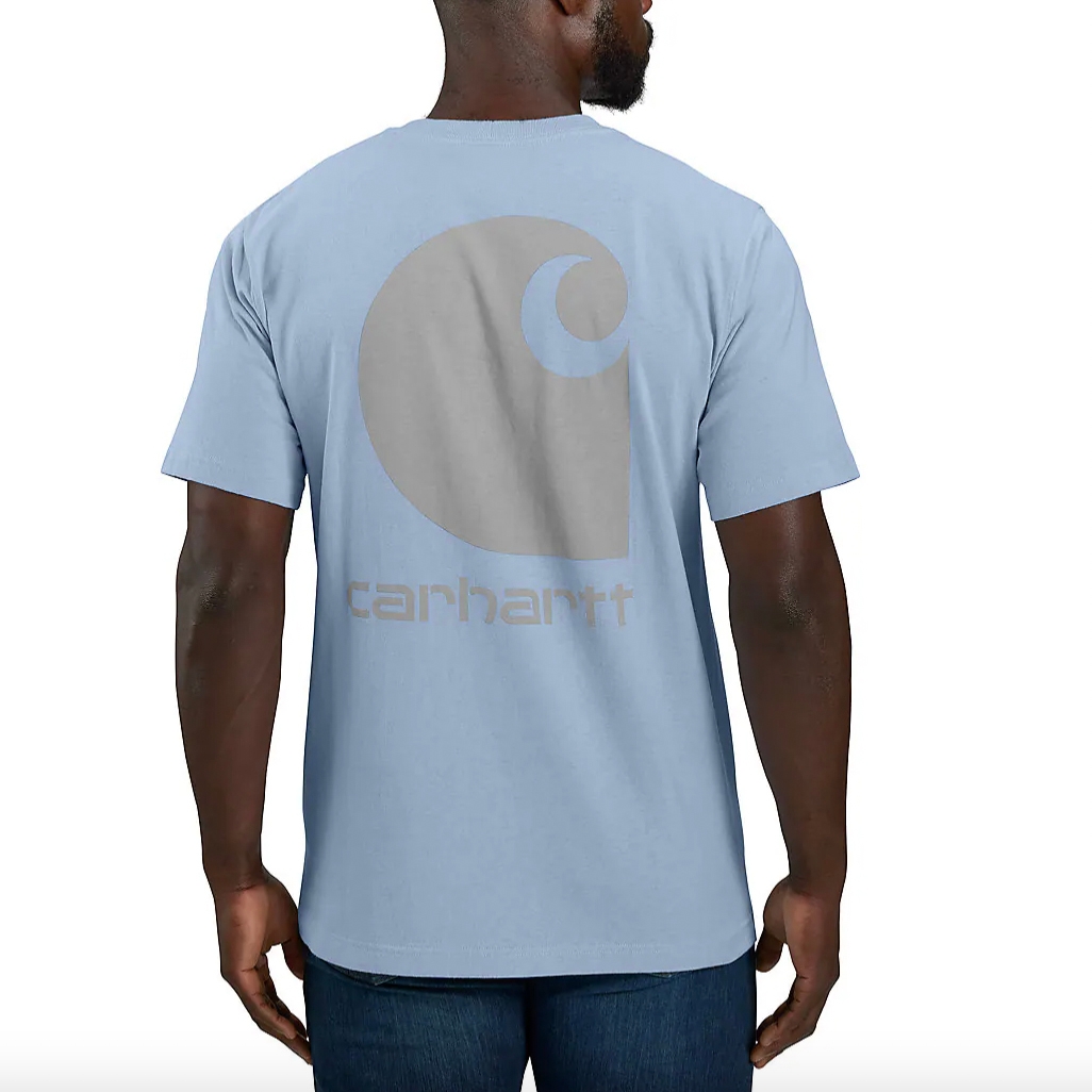 A man wearing a light blue t-shirt with a large circular logo on the back.