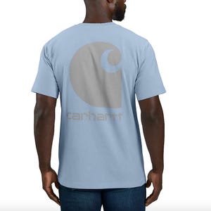 A man wearing a light blue t-shirt with a large circular logo on the back.