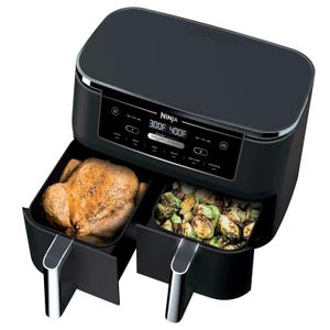 Refurbished Ninja Foodi 10qt 2-Basket Air Fryer with a digital display, featuring dual cooking zones for cooking different foods simultaneously; shown with roasted chicken and Brussels sprouts.