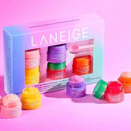 a multi colored lip treatment set on a pink background