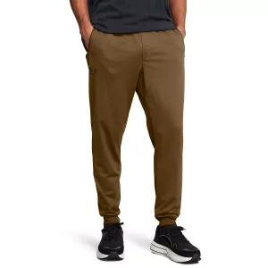 UA Men's Sportstyle Joggers in brown with a relaxed fit, featuring an elastic waistband, tapered legs, and side pockets. Logo on the left thigh. Paired with black athletic shoes.