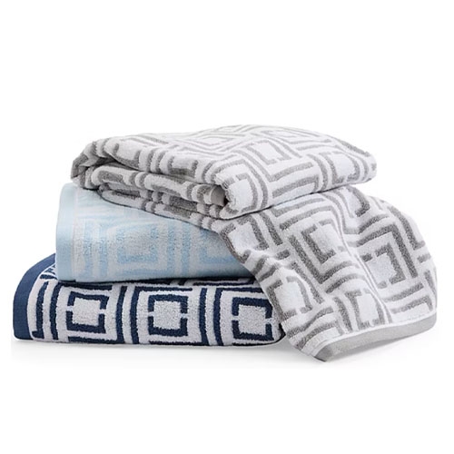 Three folded towels featuring geometric patterns in varying shades of gray, blue, and light blue.