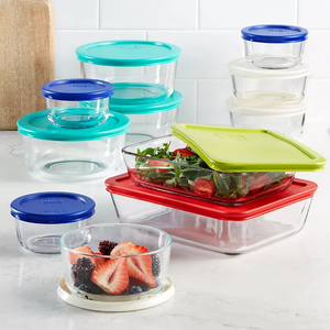 Assorted glass food storage containers with multi-colored lids, in various shapes and sizes.