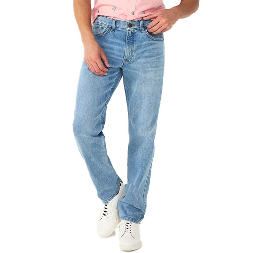 Man wearing light blue denim jeans with a pink shirt and white sneakers.