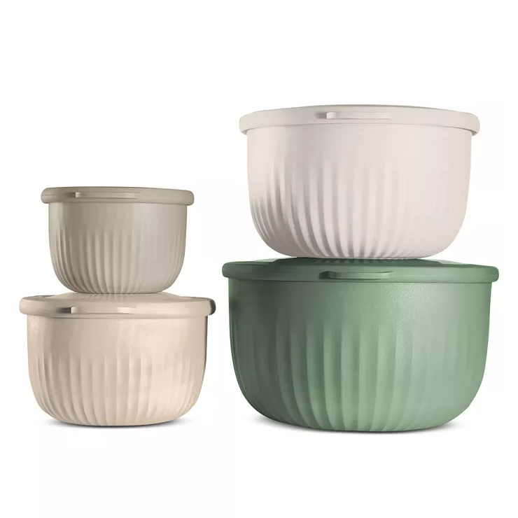 Four nesting bowls in soft green and beige tones with matching lids, featuring a ribbed texture. They are stackable, with two smaller bowls and two larger ones, designed for meal prep and storage.
