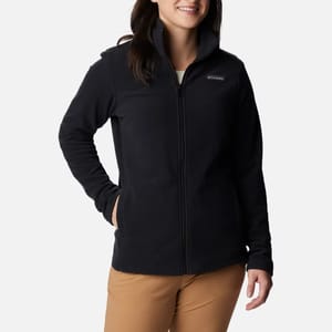 A woman wears a black full-zip fleece jacket and khaki pants.