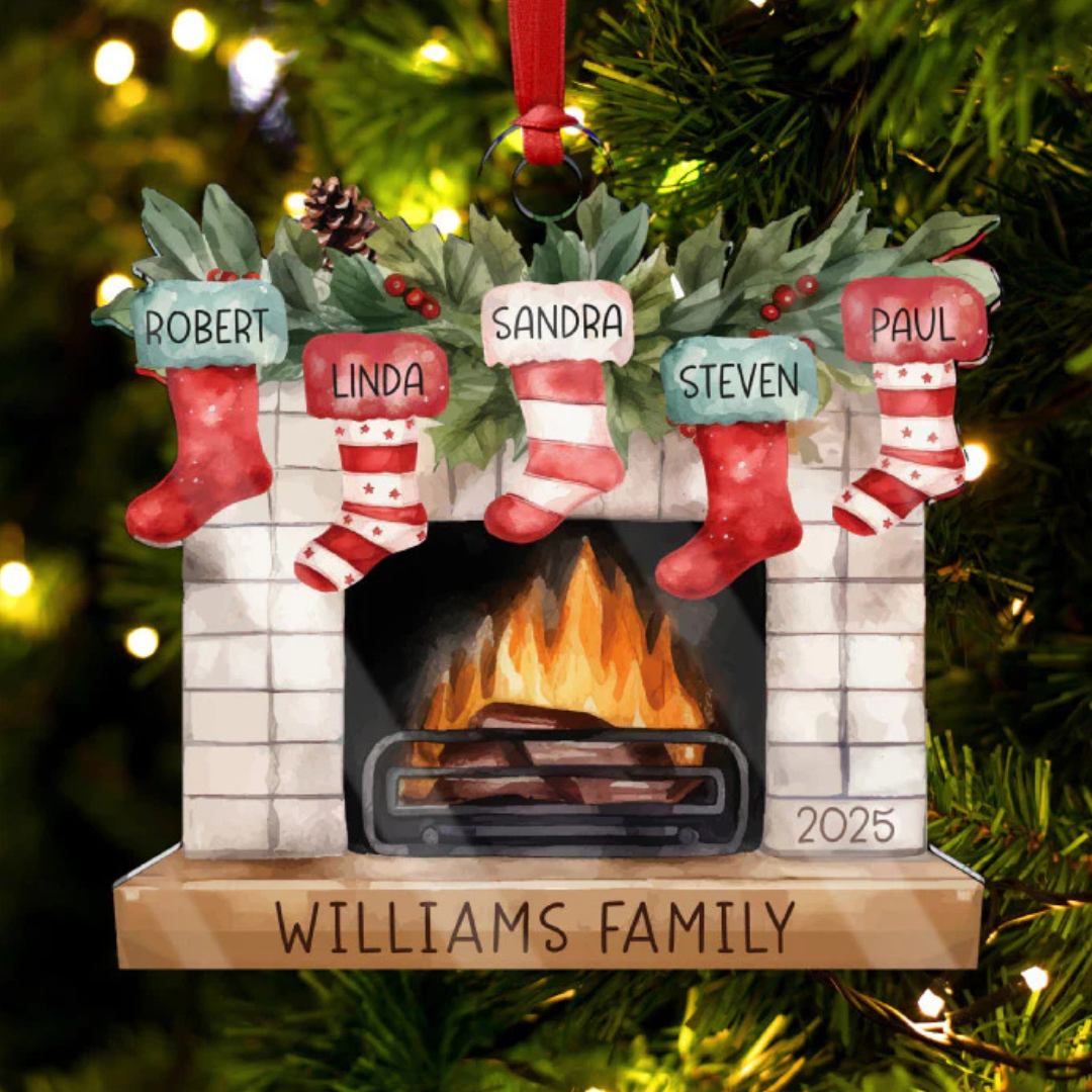A Christmas ornament featuring a fireplace with stockings labeled \“Robert,\“ \“Linda,\“ \“Sandra,\“ \“Steven,\“ and \“Paul.\“ It's labeled \“Williams Family 2025.\“