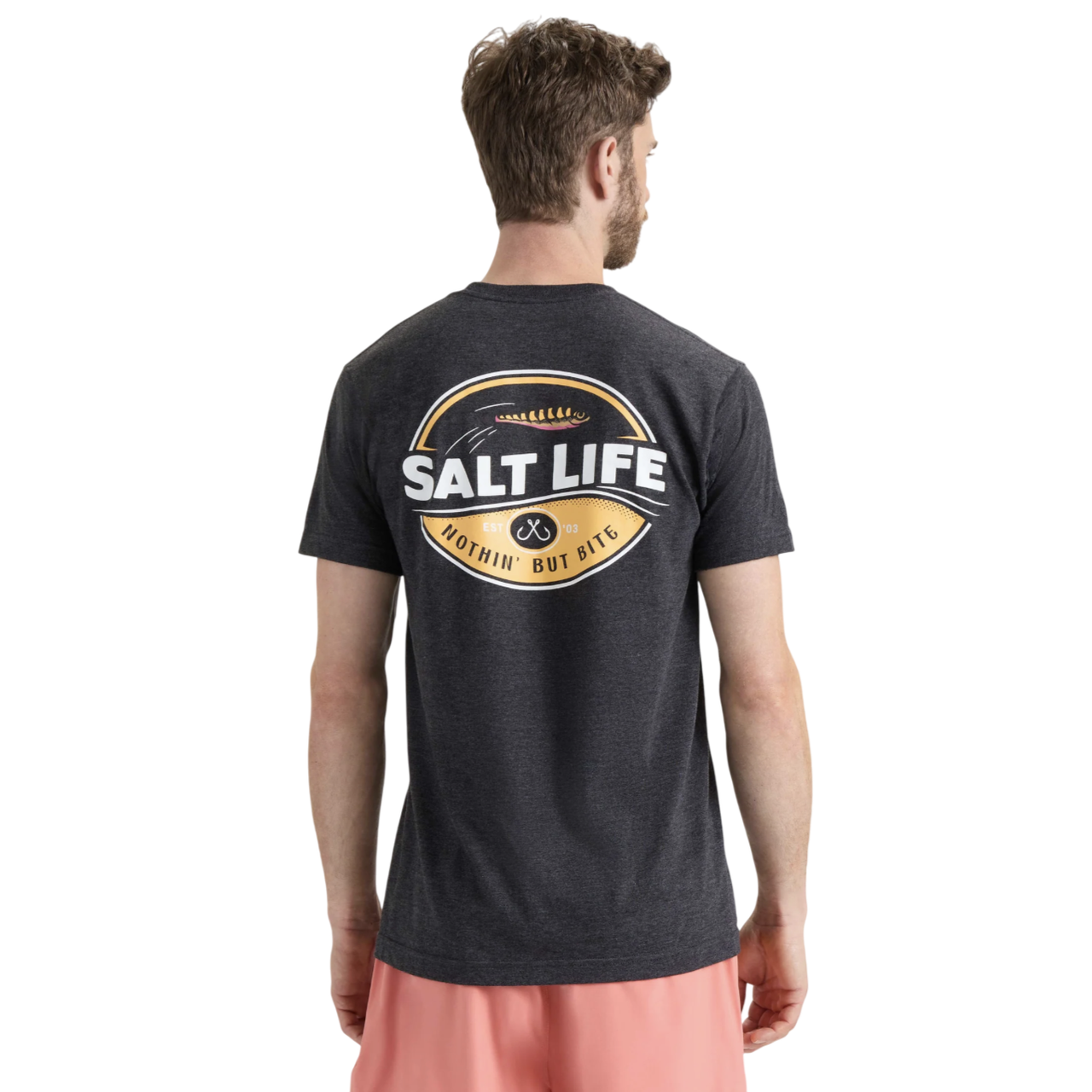 A man wearing a dark gray T-shirt with a \“Salt Life\“ logo on the back, saying \“Nothin' But Bite,\“ paired with pink shorts.