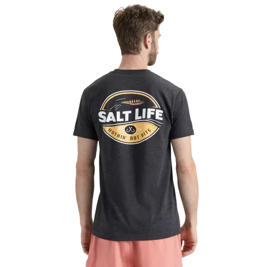 A man wearing a dark gray T-shirt with a \“Salt Life\“ logo on the back, saying \“Nothin' But Bite,\“ paired with pink shorts.