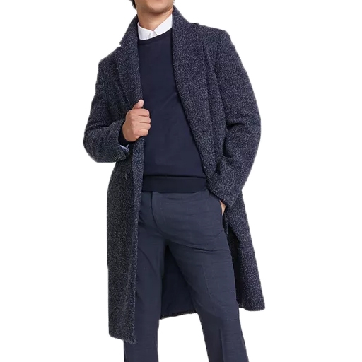 A person is wearing a long, textured navy overcoat over a dark sweater, a white shirt, and blue pants.