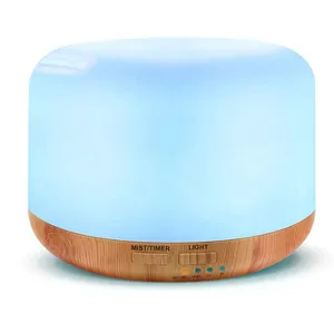 A round essential oil diffuser with a light wood base and glowing blue top, featuring controls for mist, timer, and light settings.