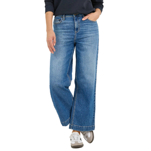 A person is wearing blue wide-leg jeans paired with white sneakers and a dark long-sleeve top.