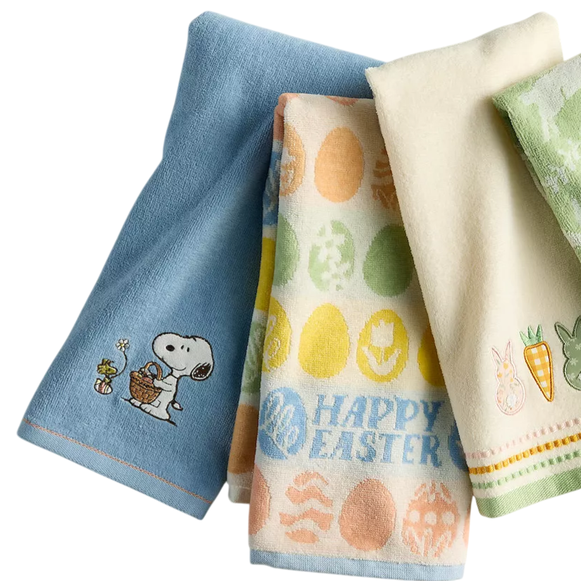 Four hand towels with Easter-themed designs, including eggs and bunnies, alongside a green bar of soap. One towel features a dog character holding a basket.